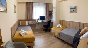 Zimmer mit 2 Betten und einem Schreibtisch mit einem Computer in der Unterkunft A&B Rhodes city apartments in Rhodos (Stadt)