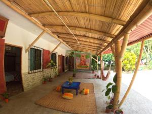 an outdoor room with a wooden ceiling and a table at MaMMa Jungla in Ayampe