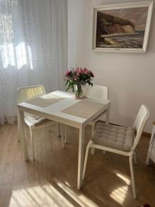 グディニャにあるOrłowo nadmorskieの白いテーブルと椅子2脚、花瓶