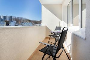 a balcony with two chairs and a table on it at Family apartment with balcony Warszawska Gdynia by Renters in Gdynia