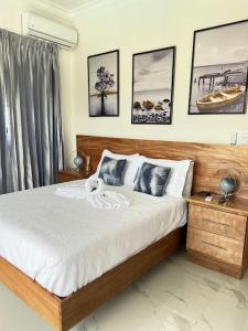 a bedroom with a large bed and pictures on the wall at Villa Valentina Holidays in Camú