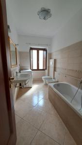ein Badezimmer mit zwei Waschbecken, einer Badewanne und zwei WCs in der Unterkunft Casa TRICAGLIO in Barisciano