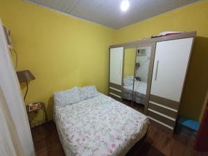 een kleine slaapkamer met een bed en een kast bij Casa de praia completa em Cabo Frio - Melhor Custo x Benefício in Cabo Frio