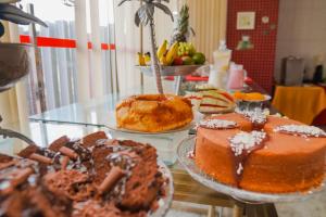 a table with different types of cakes and pastries on it at Costa Atlantico Hotel in São Luís