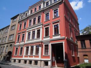 ein rot-weißes Gebäude mit einer Tür in der Unterkunft Ferienwohnung Alt Görlitz in Görlitz