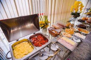 um buffet com muitos tipos diferentes de comida em uma mesa em Costa Atlantico Hotel em São Luís