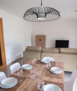 巴斯的住宿－Mestre Tornabell 11，用餐室配有带盘子和酒杯的桌子