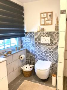 a bathroom with a white toilet in a room at Ferienhaus Goldstück wohnen im Weinberg in Pommern