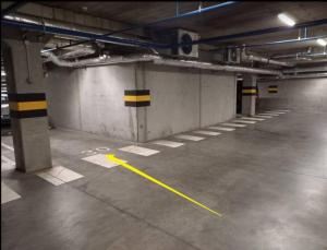 un garaje vacío con una línea amarilla en el suelo en Cozy apartment with underground parking en Vilna