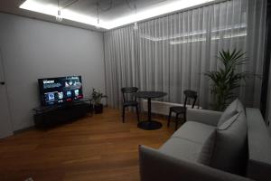 sala de estar con sofá, mesa y TV en Cozy apartment with underground parking en Vilna