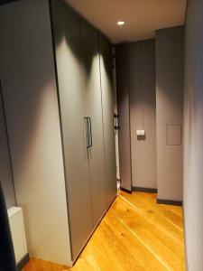 un corridoio vuoto con due porte e un pavimento in legno di Cozy apartment with underground parking a Vilnius