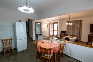 a kitchen and dining room with a table and a refrigerator at Uliveto 3bd Rustic House in Kardamaina