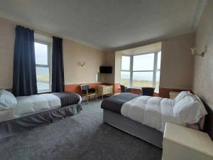 um quarto de hotel com duas camas e uma secretária em The Sandbanks em Barmouth