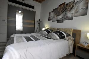 una camera da letto con un grande letto bianco con due cuscini di L'Antico Camino - Alloggio Turistico ad Acquapendente