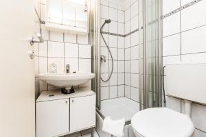 a white bathroom with a toilet and a sink at Work and Stay Koeln Ostheim in Cologne