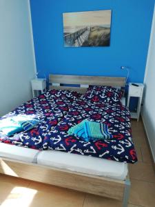 een slaapkamer met een bed met een blauwe muur bij Ostseetraum Igelring in Gelbensande
