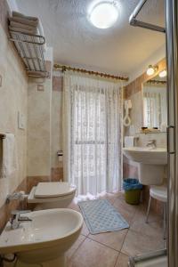 baño con 2 aseos y lavamanos en Hotel Cecchin, en Aosta