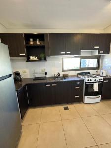 a kitchen with black cabinets and a white stove top oven at Departamento INCREIBLE!!!! in Corrientes