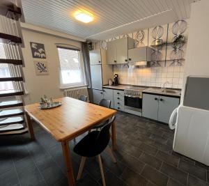 a kitchen with a wooden table and a kitchen with appliances at Apartments Marienburg in Nordstemmen