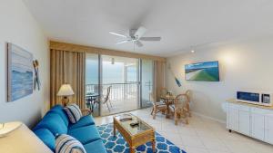 sala de estar con sofá azul y mesa en Beachfront 1 Bed w/ On Site Tiki Bar/Restaurant! en Marco Island