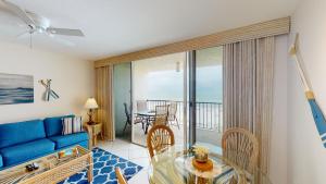 a living room with a blue couch and a glass table at Beachfront 1 Bed w/ On Site Tiki Bar/Restaurant! in Marco Island