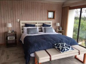 a bedroom with a large bed and a large window at Casa en la playa entre Pichidangui y Los Vilos in Los Vilos