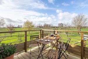 una terrazza in legno con tavolo e sedie. di Le Sommelier a Bailleul