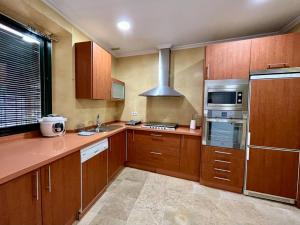 a kitchen with wooden cabinets and a stove top oven at Apartamento Suite Alameda de Hercules in Seville