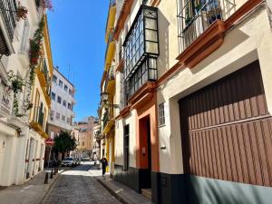 een steegje met gebouwen en een persoon die door een straat loopt bij Apartamento Suite Alameda de Hercules in Sevilla