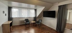 a room with two chairs and a table and a television at Apartments Marienburg in Nordstemmen