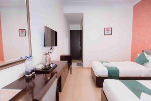 a hotel room with two beds and a sink and a mirror at Plaza Residency in Gurgaon
