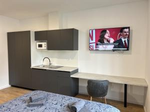 a kitchen with a sink and a tv on the wall at Park Maksimir Apartments in Zagreb