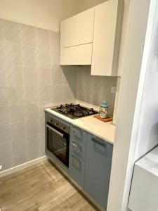 a kitchen with a stove and white cabinets at Loano: Centro e Mare a portata di mano in Loano