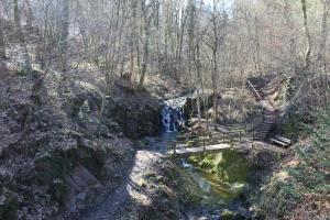 a bridge over a creek with a waterfall at Haus zur Entersburg in Bad Bertrich