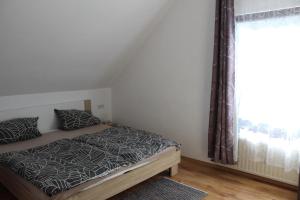 a bedroom with a bed and a window at Haus zur Entersburg in Bad Bertrich