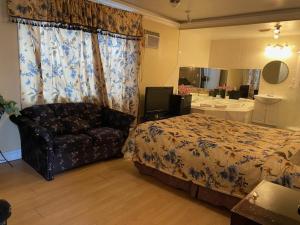 ein Schlafzimmer mit einem Bett, einem Sofa und einem Spiegel in der Unterkunft Motel Pierre in Montreal