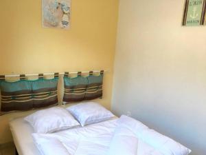 uma cama num quarto com duas almofadas em gite le ptit bleu maison totalement indépendant em La Tremblade