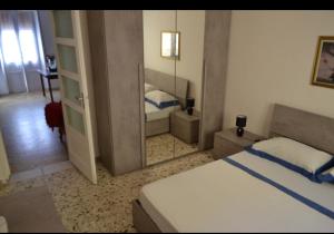 1 dormitorio con 1 cama grande y espejo en Flat in Olbia Centro, en Olbia