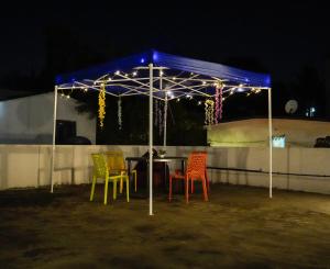 een tafel met kleurrijke stoelen onder een tent 's nachts bij Elite stays in Pune