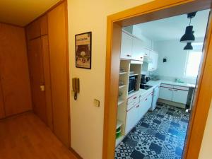 kuchnia z białymi szafkami i drzwiami do pokoju w obiekcie Calme Lumineux Spacieux Accueillant w Miluzie