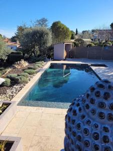 uma piscina com água azul num quintal em Maison avec piscine, oliviers, belle vue, au calme em Trans-en-Provence