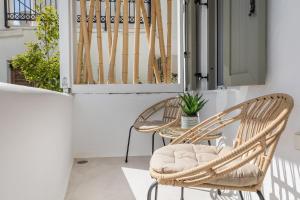two wicker chairs and a table on a balcony at En Lefko boutique house in Naxos Chora