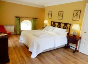 1 dormitorio con cama blanca y ventana en The Courtyard Kilshannig en Fermoy