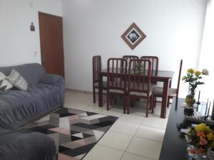 a living room with a couch and a table and chairs at Apartamento Marina Clube Vista Lagoa in Cabo Frio