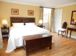 sypialnia z dużym łóżkiem i drewnianą podłogą w obiekcie The Courtyard Kilshannig w mieście Fermoy
