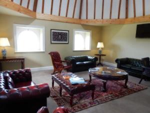 a living room with leather furniture and a table at The Courtyard Kilshannig in Fermoy