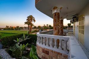 a house with a brick wall and a fence at Noby Guest House in Luxor