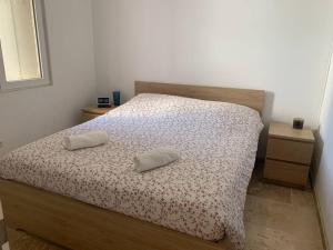 a bedroom with a bed with two pillows on it at Appartement à 200m des plages. in Fréjus
