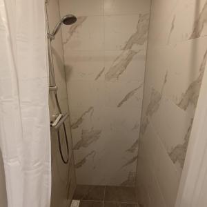 a bathroom with a shower with a marble wall at Vakantiehuisje Martina 24 in Vlissingen +22 photos