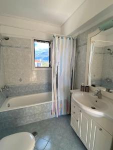 łazienka z umywalką, wanną i toaletą w obiekcie Country house Nafpaktos w mieście Nafpaktos